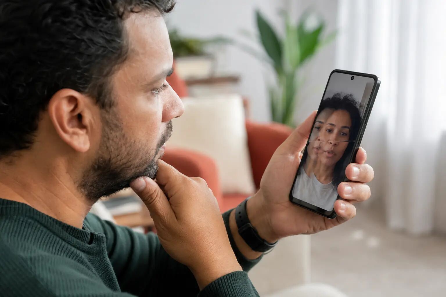 Pessoa observa com atenção uma videochamada suspeita no celular